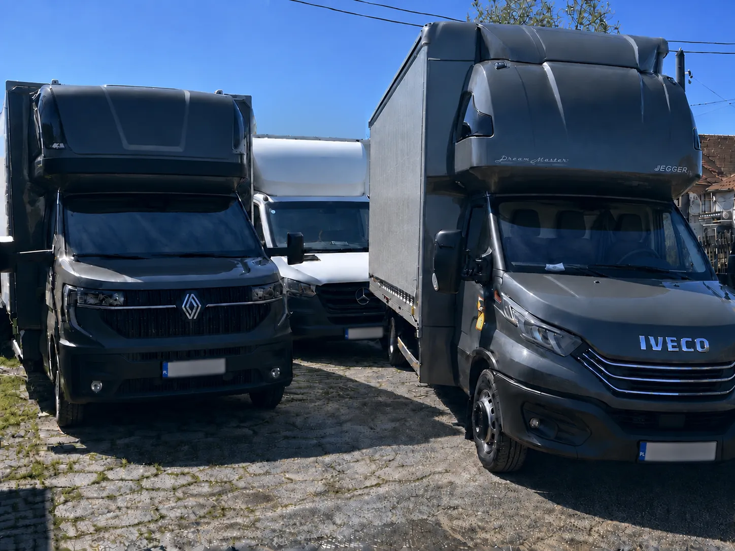 Trzy samochody dostawcze floty M&S Transport z ukrytymi tablicami rejestracyjnymi
